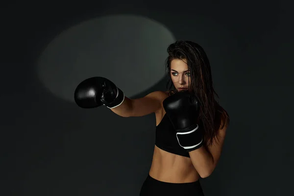 sporty woman with black boxing gloves