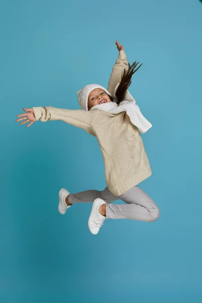 Маленькая девочка в зимнем трикотаже шляпа и свитер прыжки — стоковое фото