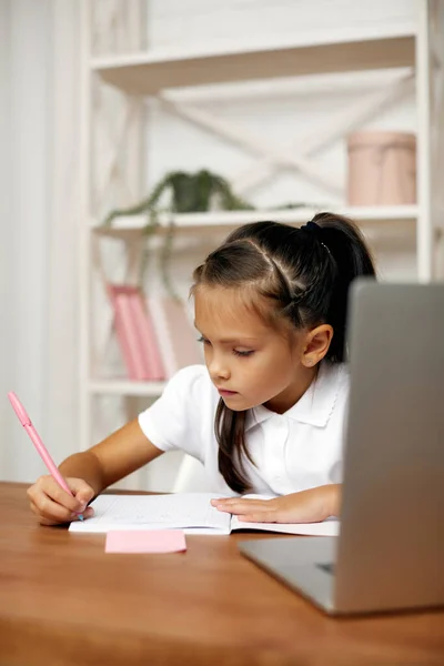 Klein meisje met behulp van laptop voor online les thuis — Stockfoto