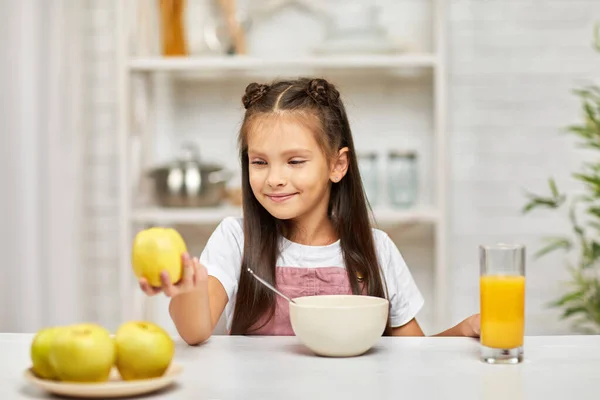 Мила маленька дівчинка сніданок - крупа та апельсиновий сік — стокове фото
