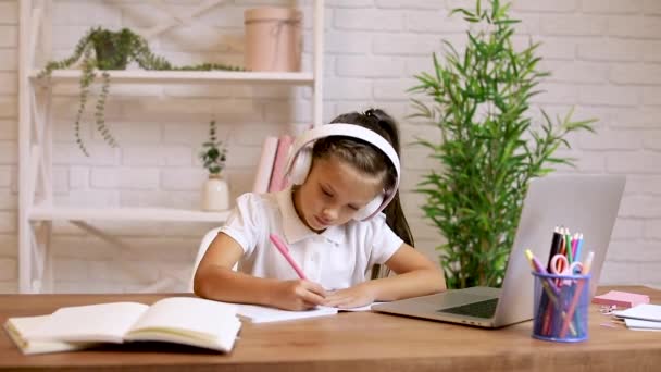 Kisgyerek lány használja laptop elvégzésére iskolai feladatok otthon és jegyzeteket írni. — Stock videók