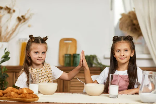 Маленькі дівчатка, які снідають - свіжі смачні круасани та молоко — стокове фото