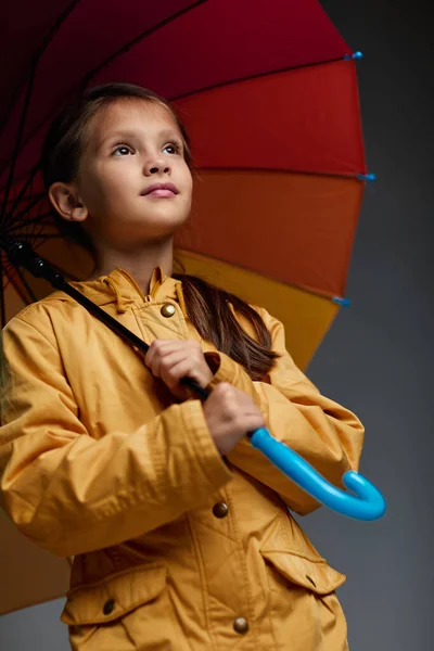 Весела дівчинка з парасолькою на сірому фоні . — стокове фото