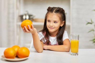 Portakallı ve meyve suyu içen küçük kız..
