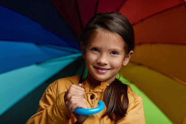 Весела дівчинка з парасолькою на сірому фоні . — стокове фото