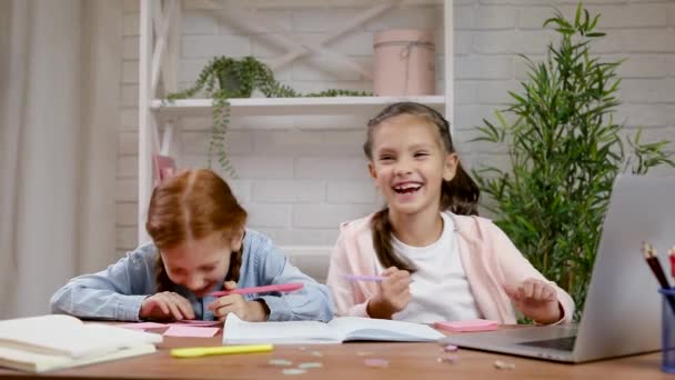 Två små barn flicka med bärbar dator för att göra skoluppgifter hemma — Stockvideo