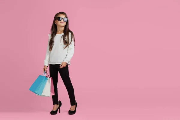 Menina em óculos de sol está segurando sacos de compras — Fotografia de Stock