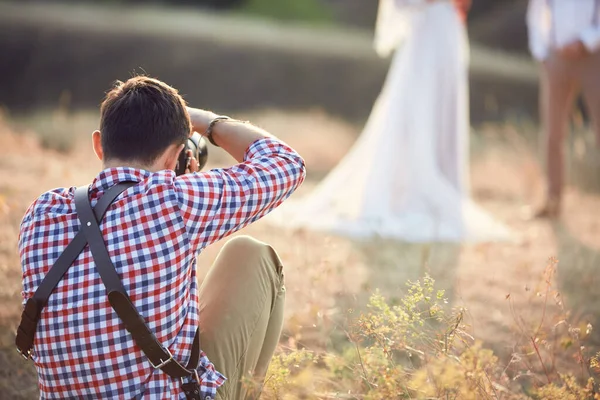 Свадебный фотограф фотографирует жениха и невесту — стоковое фото