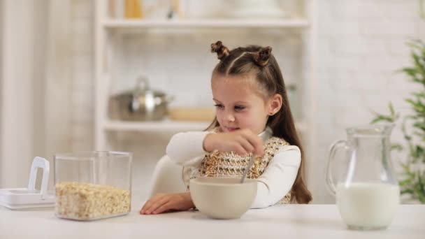 Child put cereal in a bowl — Stock Video