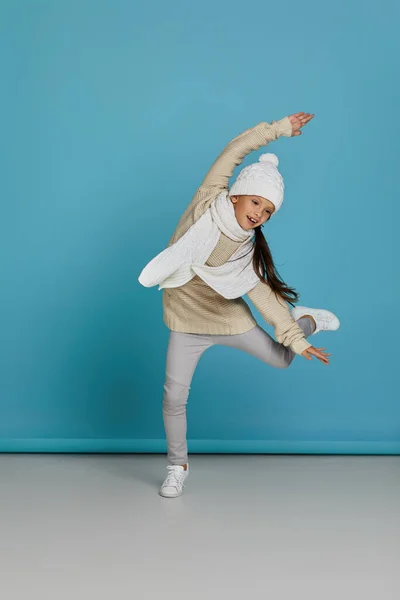 Menina no inverno tricotado chapéu e suéter saltando — Fotografia de Stock