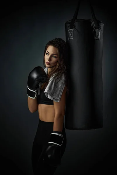 演播室背景下戴黑色拳击手套的女运动员 — 图库照片