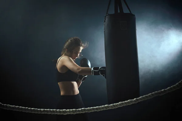 Mujer morena deportiva en guantes de boxeo puñetazos —  Fotos de Stock