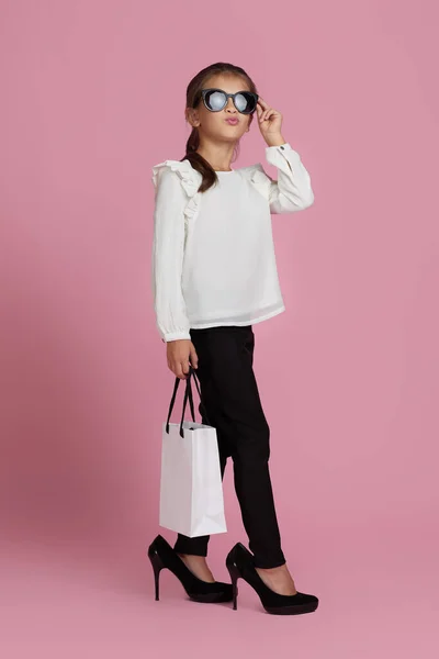 Dítě dívka v slunečních brýlích drží nákupní tašky — Stock fotografie
