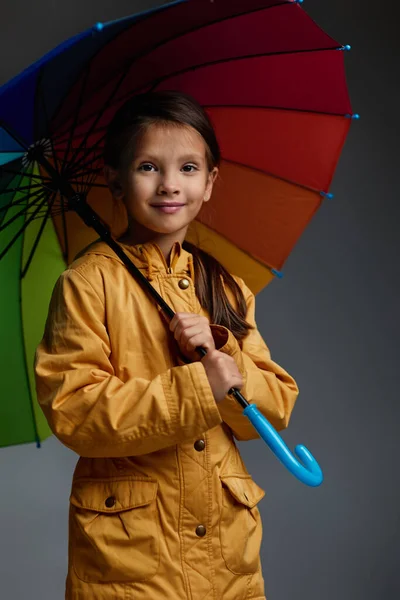 Menina alegre com guarda-chuva no fundo cinza. — Fotografia de Stock