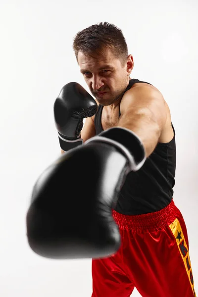 Спортивний чоловік в чорних боксерських рукавичках, пробиваючи — стокове фото