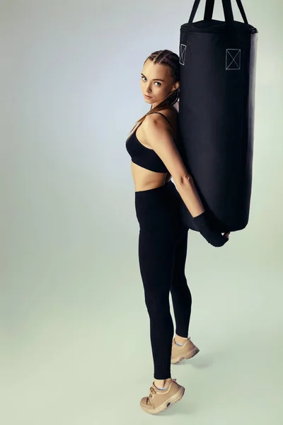 Donna in abbigliamento sportivo con bende da boxe vicino alla borsa — Foto Stock