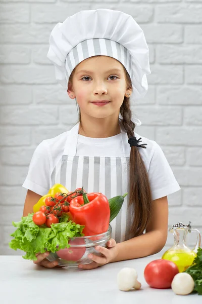 Kleines Mädchen hält Schüssel mit frischem Gemüse — Stockfoto