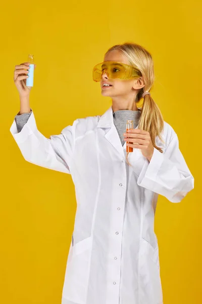 Klein meisje met een chemisch flesje en reageerbuis — Stockfoto