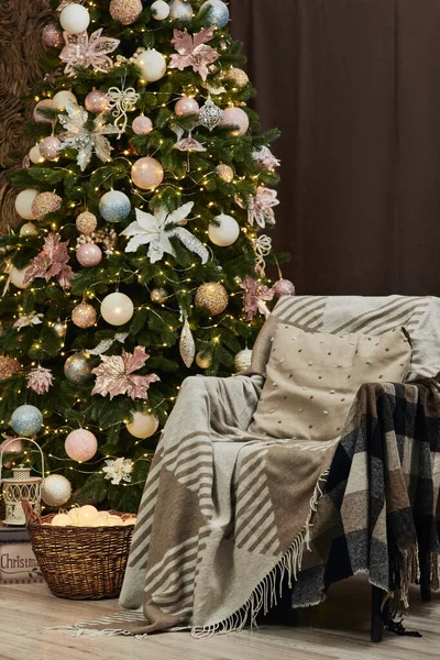 Fauteuil avec couverture chaude et sapin de Noël décoré. — Photo