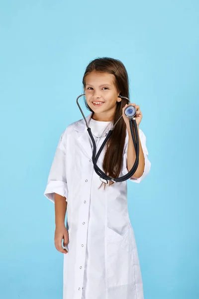 Bambino carino in cappotto medico con stetoscopio — Foto Stock