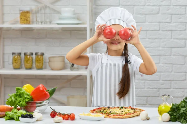 Das Kind mit der roten Tomate. — Stockfoto
