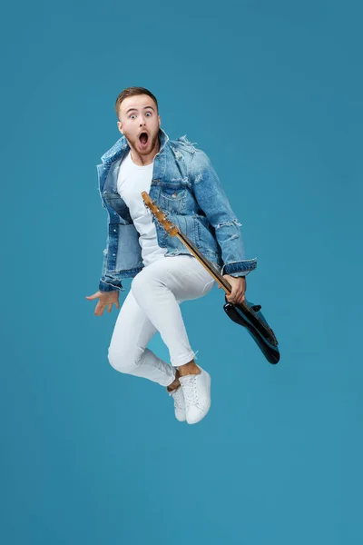 Homme en denim t-shirt jeans avec saut à la guitare — Photo