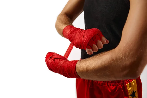 Uomo sportivo avvolge le mani in bende sportive rosse — Foto Stock