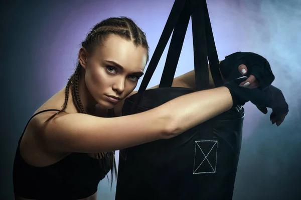 Спортивная брюнетка с боксерскими повязками рядом с сумкой — стоковое фото