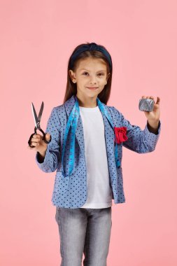 Sevimli küçük kız elinde mezura ve iplik tutuyordu.