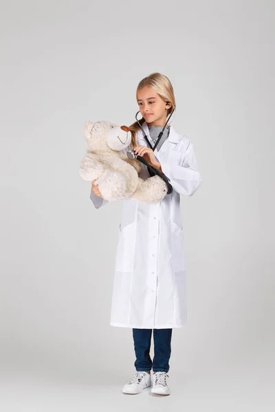 Bambino carino in cappotto medico con stetoscopio — Foto Stock