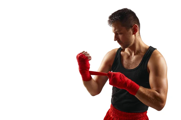 Hombre deportivo envuelve sus manos en vendajes deportivos rojos — Foto de Stock