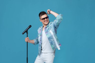 Kotlu, mikrofonlu yakışıklı adam.