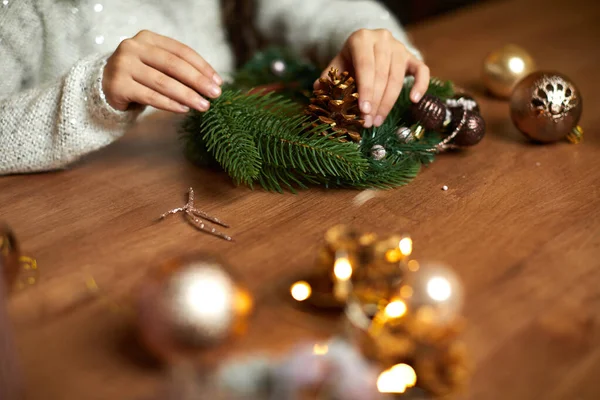 Küçük kız el yapımı Noel çelengi yapıyor. — Stok fotoğraf