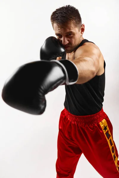 Hombre deportivo en guantes de boxeo negro puñetazos —  Fotos de Stock