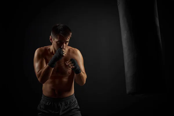 Мужской боксер бьет боксерскую сумку — стоковое фото