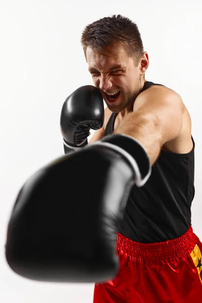 Sportovní muž v černé boxerské rukavice punching — Stock fotografie