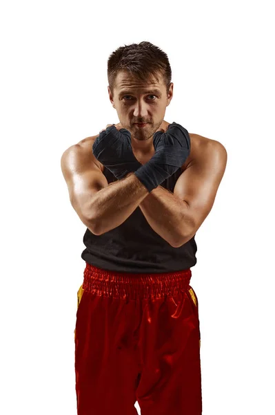 Uomo sportivo in bendaggi sportivi rossi sulle mani che combatte — Foto Stock