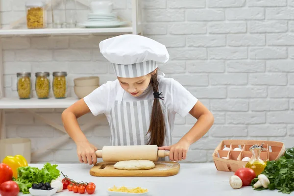 Kleines Mädchen rollt Teig aus — Stockfoto