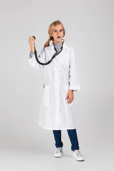 Симпатична дитина в медичному пальто зі стетоскопом — стокове фото