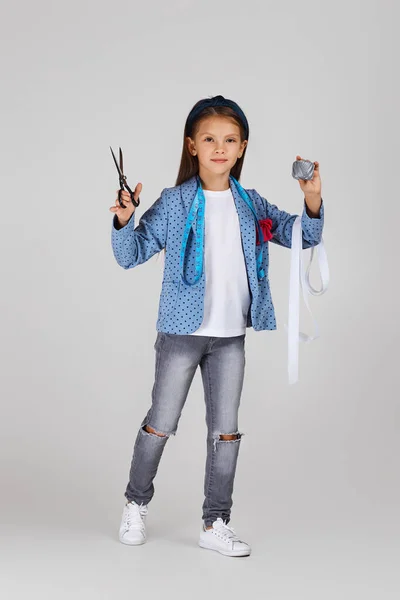 Чарівна маленька дівчинка тримає міру стрічки і котушку нитки — стокове фото
