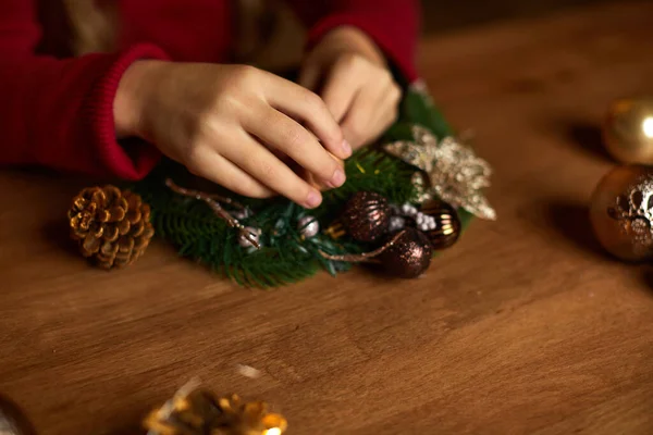 Küçük kız el yapımı Noel çelengi yapıyor. — Stok fotoğraf