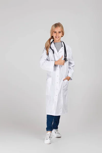 Bambino carino in cappotto medico con stetoscopio — Foto Stock