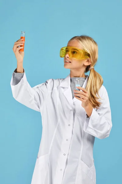 Menina criança segurando um frasco químico e tubo de ensaio — Fotografia de Stock