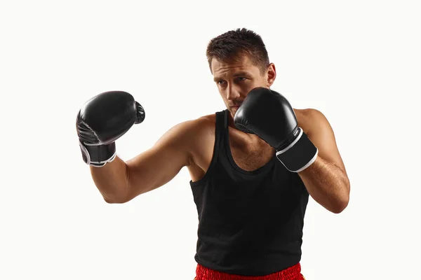 Hombre deportivo en guantes de boxeo negro puñetazos — Foto de Stock