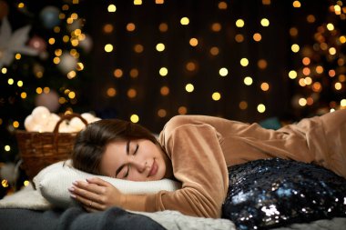 Uzun saçlı güzel genç bir kadın yatakta yatıyor.