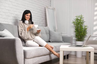 Laptop kullanan çekici genç bir kadın.