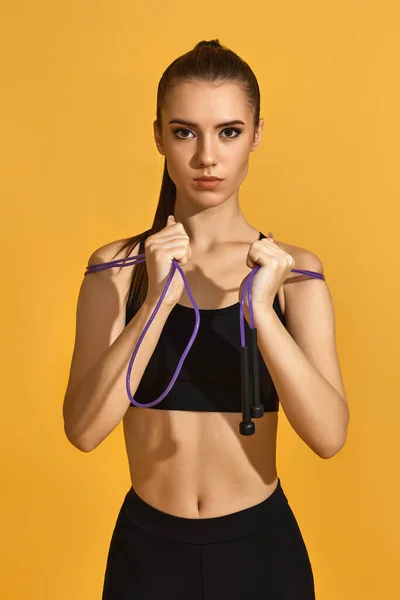 Mulher em sportswear preto com corda de salto — Fotografia de Stock