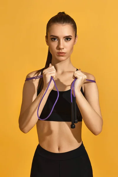 Mujer en ropa deportiva negra con cuerda de salto —  Fotos de Stock