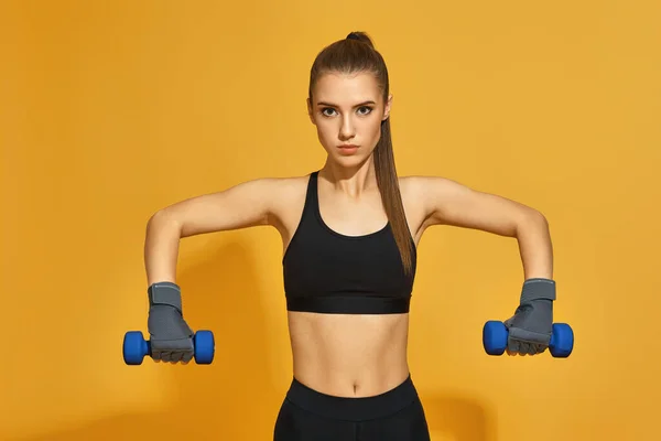 Mujer en entrenamiento de ropa deportiva negra con mancuernas — Foto de Stock