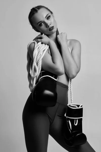 fashion sexy gorgeous woman model with black boxing gloves and white rope